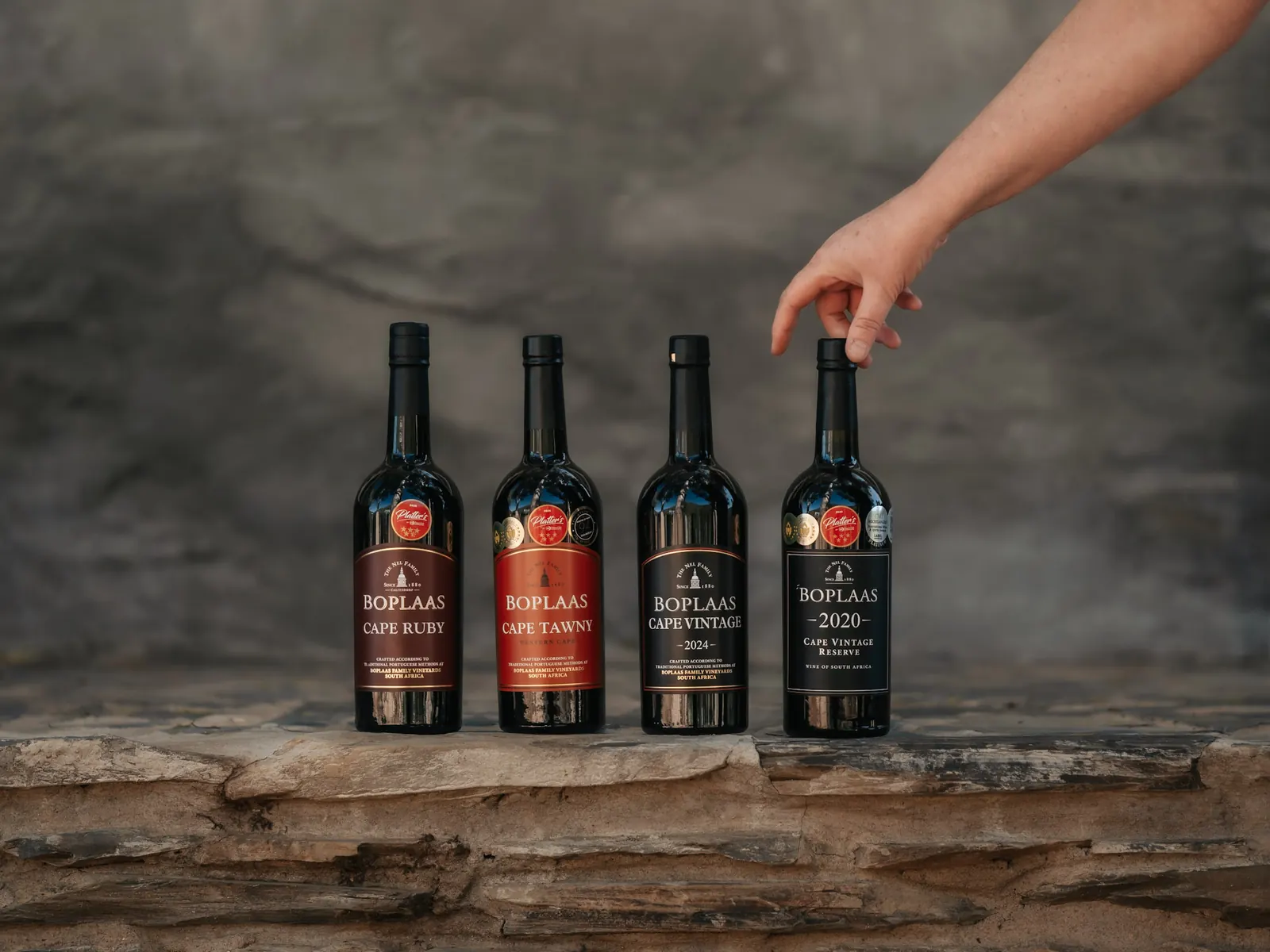 Four Boplaas port bottles on a stone ledge, photographed by Web Brew